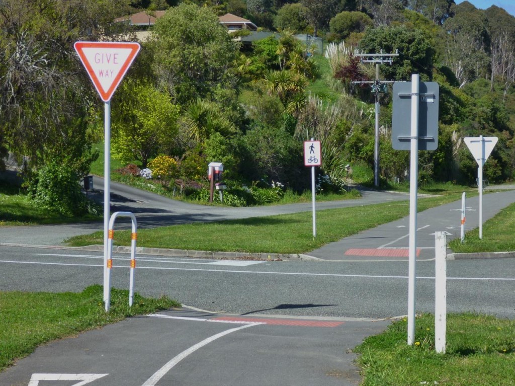 Cyclists and pedestrians give way to vehicle flow. 