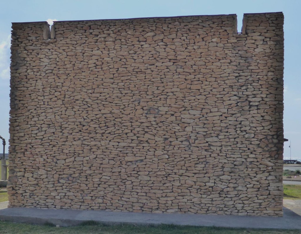 The back wall of a beach side park bathroom. 