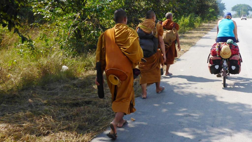 Monks on a pilgrimage. We have seen many walking south. Black feet and thin sandals. Ouch. We prefer the bike. We don't know what that thing on his butt is though. 