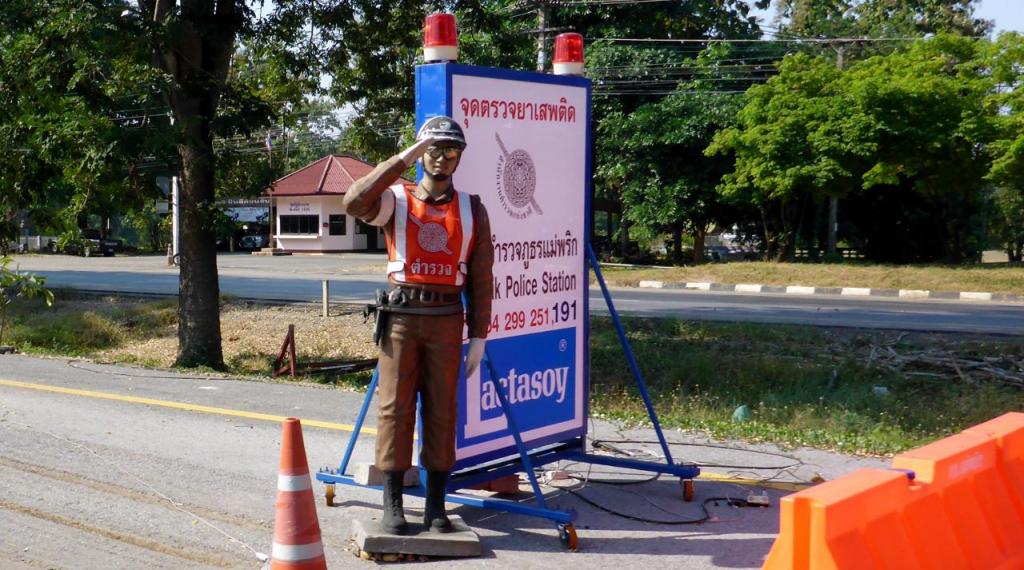 A Thai police statue at one of many police road stops. 