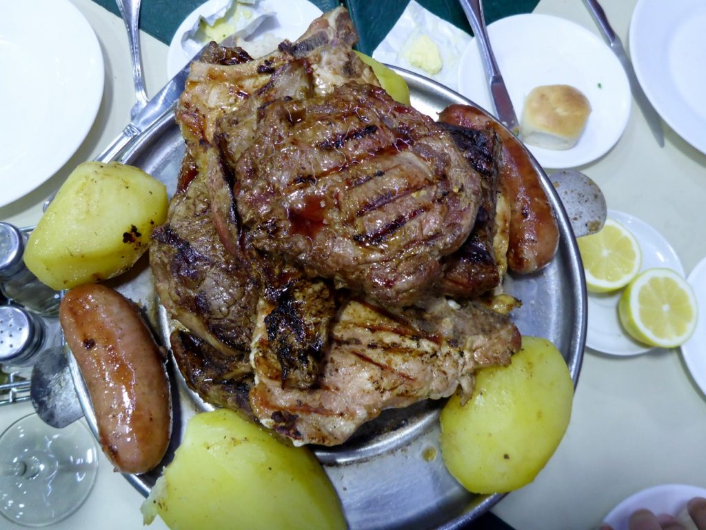 A delicious Argentinean beef lunch. The meat is partially cooked and placed on this barbecue to continue cooking. So everyone eats when it is cooked to their taste.