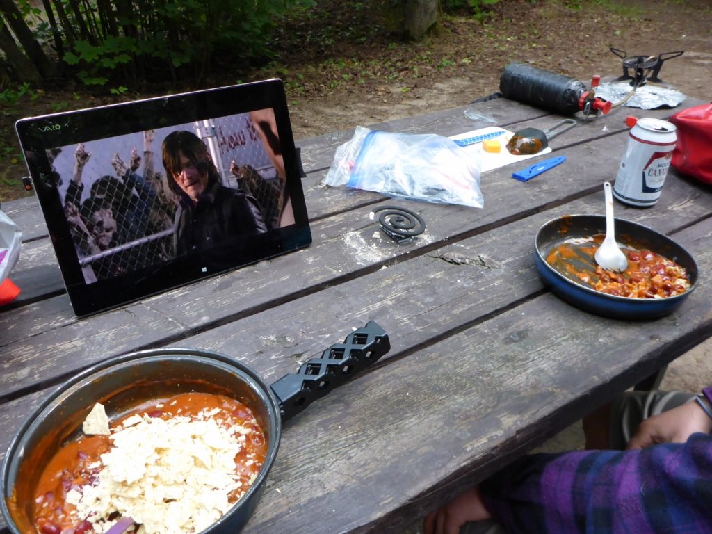 Watching the Walking Dead during a fine camp meal.
