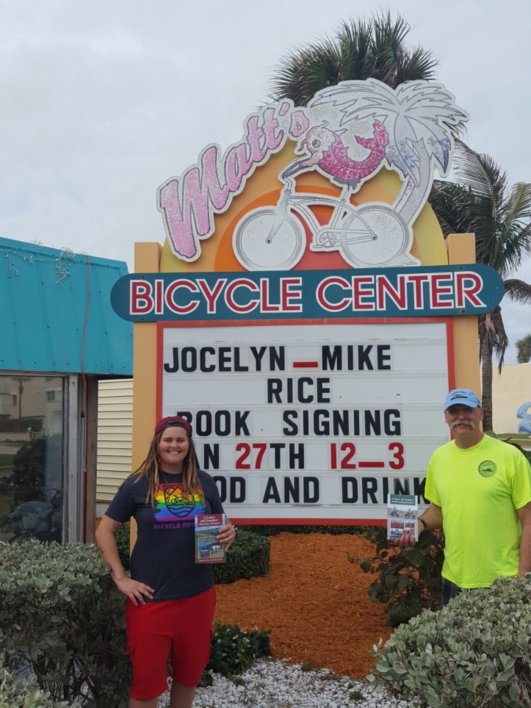 Outside of Matt's Bicycle Center in Cocoa Beach with both of our world journey books.